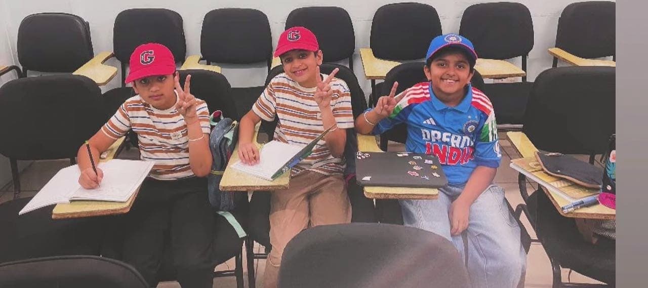 Three children writing in a classroom